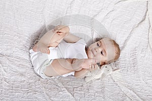 Innocent baby girl playing on the bed