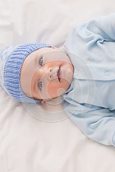 Innocent baby wearing knit hat in bed