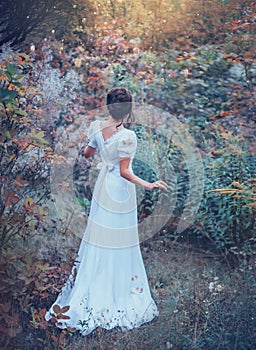 Innocent charming girl in a long white vintage expensive dress got lost in the forest, lost her way, cool colors photo