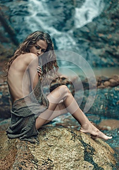 Innocent lady resting on the sharp rock