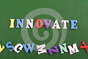 INNOVATE word on green background composed from colorful abc alphabet block wooden letters, copy space for ad text. Learning