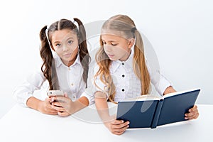 Innovation and archaism concept. Children read paper book and electronic mobile device using innovation and archaism