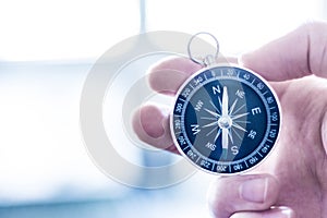 Innovation concept: Man is holding a compass in his hand, closeup cutout