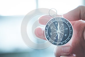 Innovation concept: Man is holding a compass in his hand, closeup cutout