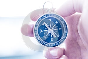 Innovation concept: Man is holding a compass in his hand, closeup cutout