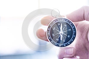 Innovation concept: Man is holding a compass in his hand, closeup cutout