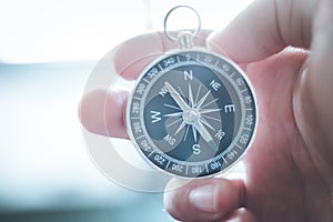 Innovation concept: Man is holding a compass in his hand, closeup cutout