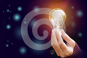 Innovation or creative concept of hand hold a light bulb on bokeh background.