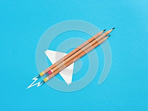 Innovation, creativity and education. Improving the educational system. Back to school. Rocket made from school pencils on blue