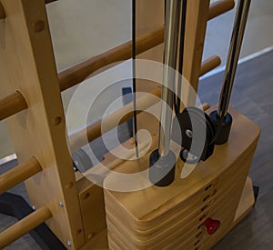 Innovative, special wooden weight stack simulator close up in the gym, different weight, stylish design yellow