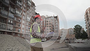 An innovative supervisor in construction in helmet and wearer checks materials and checks quantity against the documents