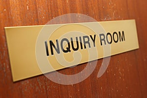 Inquiry room sign on a wooden door.