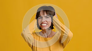 Insane Woman Covering Ears With Hands Shouting No, Yellow Background
