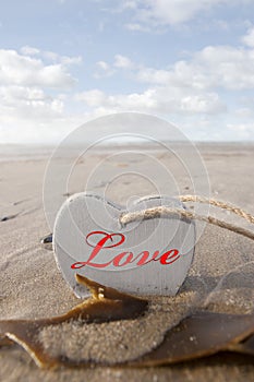 Inscribed wooden love heart in the sand