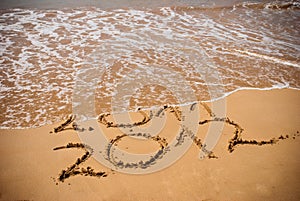 Inscription 2011 and 2012 on a beach sand