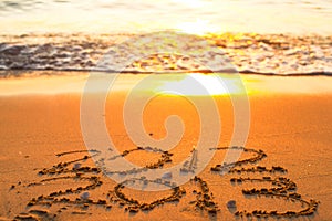 Inscription 2012 and 2013 on a beach sand