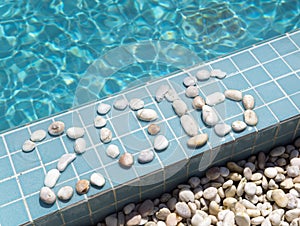 The inscription 2016 is laid out by pebble on a pool side