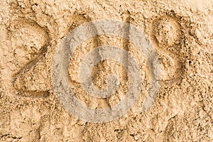 Inscription 2018 on the yellow sand