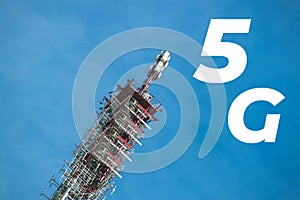 Inscription 5G and telecommunication, cellular tower and antenna. Radio tower with 4G, 5G network against blue sky