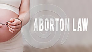 The inscription abortion law and chained hands of a pregnant woman,
