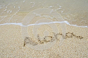 Inscription aloha on the sand at the beach.