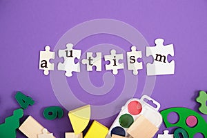 Inscription autism on plasmas, purple background, copy space, developing toys and paints for training and diagnosis