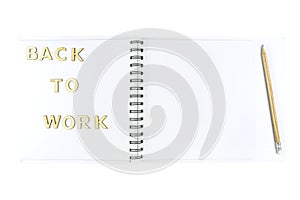 The inscription `back to work` made of wooden letters lying on an open notebook with white pages, isolated on a white background w