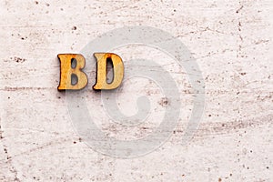 Inscription BD BDAY birthday abbreviation in wooden letters on a light background