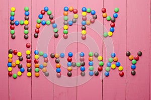 Inscription from candies on a pink background