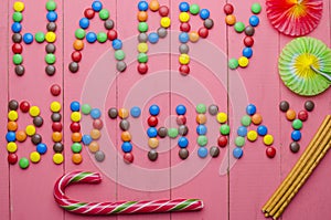 Inscription from candies on a pink background