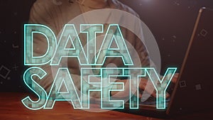 The inscription in capital letters, the data safety, against the background of a man working on a laptop.