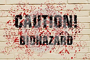 Inscription Caution Biohazard on a bloodstained brick wall.