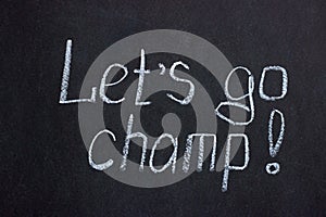 The inscription on the chalkboard `let`s go, champ`. Motivating phrase