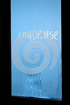 Inscription condense on glass with drops of condensed vapor with drops of water. Close up detail of moisture condensation problems