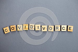 Inscription covidivorce made by wooden blocks on gray background. broken family concept