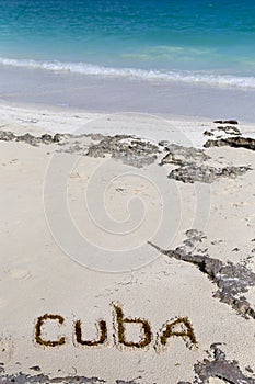 Inscription cube on the dense sand of the beach.