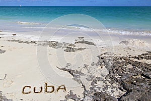 Inscription cube on the dense sand of the beach.