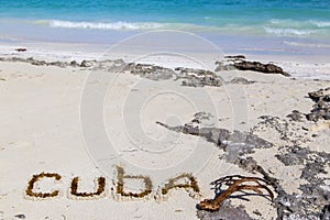 Inscription cube on the dense sand of the beach.