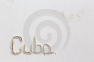 Inscription cube on the dense sand of the beach.