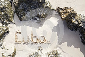 Inscription cube on the dense sand of the beach.