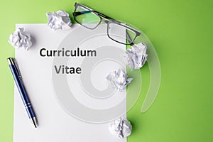 The inscription & x22;Curriculum vitae& x22; On a sheet of paper. Green background. Pen and glasses. Place for text