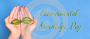 The inscription Day of ecological knowledge on a blue background with hands with a green sprout, baner