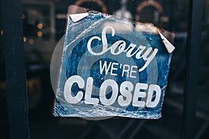 Inscription on a door: Sorry we are closed. Conceptual photo or table on door with information of work. Announcement or