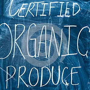 Inscription on a farmers` market for certified organic produce written on a blackboard with chalk.