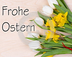 Inscription Frohe Ostern with fresh flowers