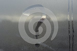 The inscription on glass, question mark concept. Question sign is painted on the surface of misted and wet window.