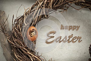 The inscription Happy Easter on the background and side view of an egg on twigs