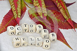 inscription hello october on a background of colorful autumn leaves