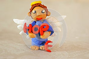 The inscription hope. Next to it is an angel figurine made of plasticine