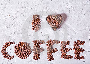 The inscription I love coffee is made of coffee beans on a concrete background